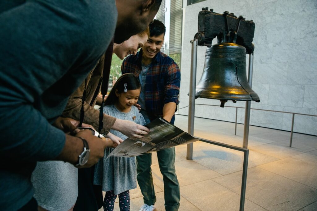 Family reading a pamphlet next to the Liberty Bell in Philadelphia, PA.