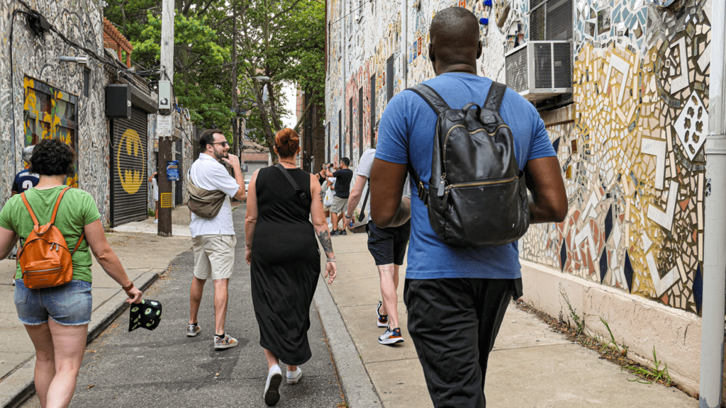 A guide leads the It's Always Sunny Tour of Philadelphia Tour through a mosaic street.