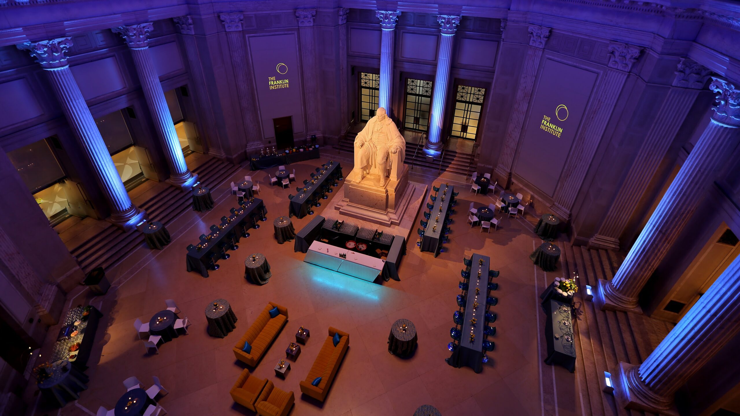 An overhead shot of an event set up around the Benjamin Franklin monument in the lobby of The Franklin Institute.