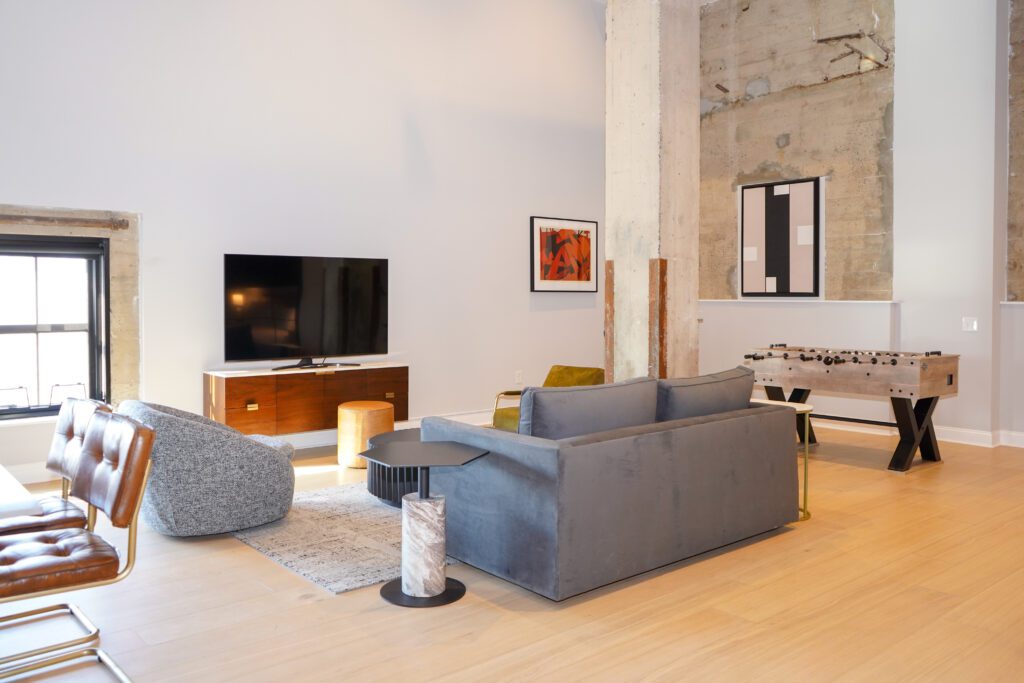 A room at the Riversuites at the Battery with a grey couch, television, and other decorations. 