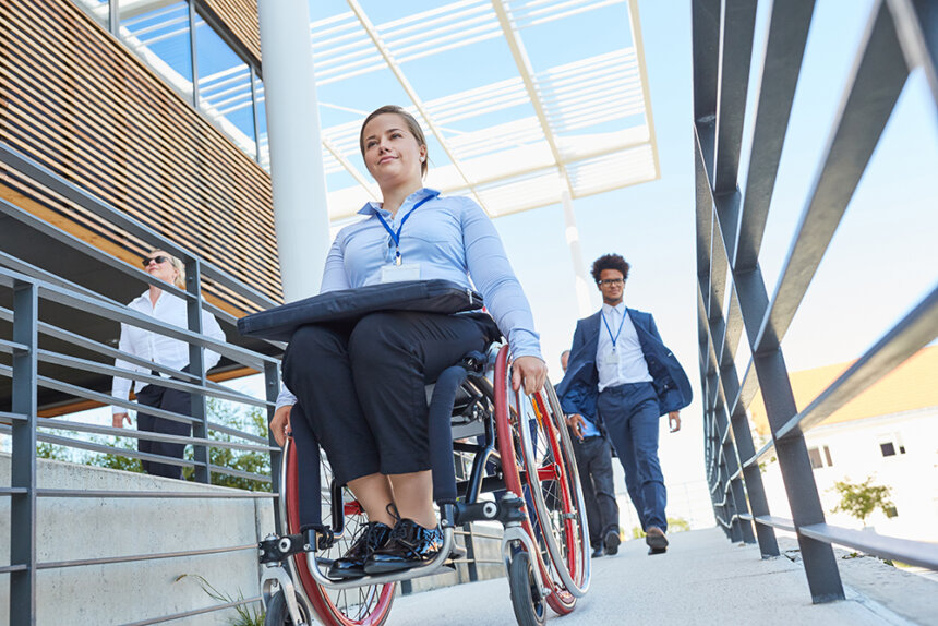Woman in a wheelchair on a ramp to the barrier-free business office