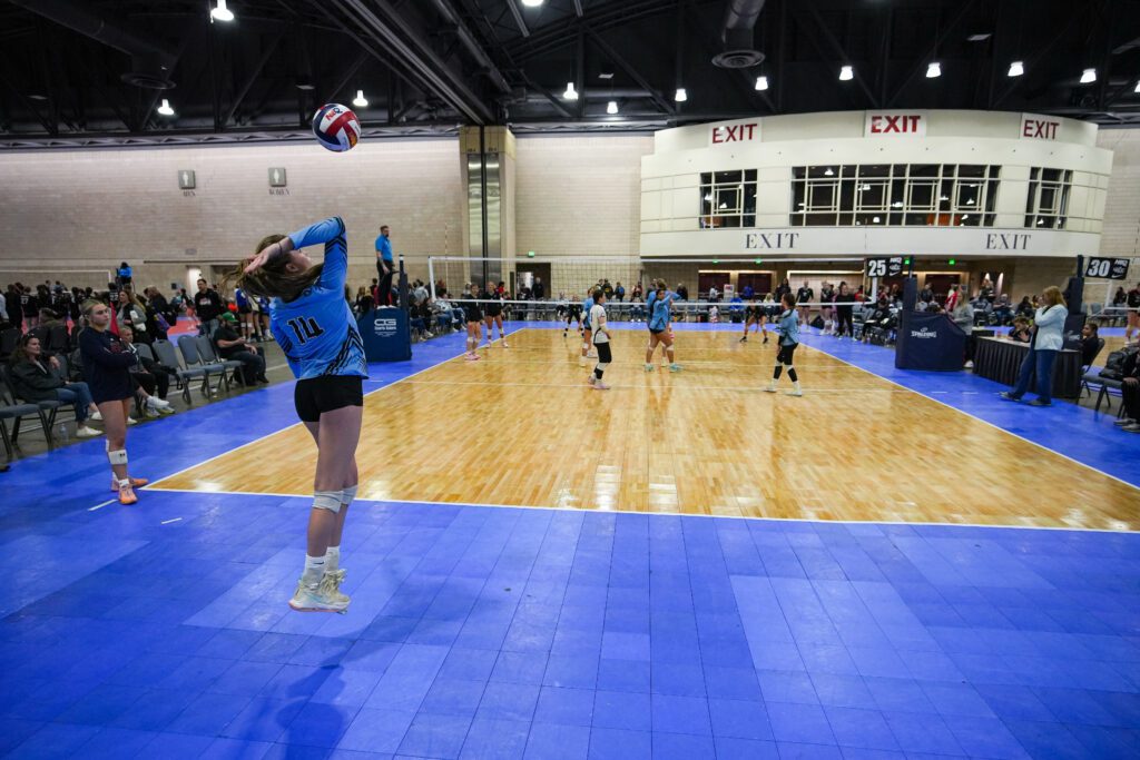 A player is serving a vollyball on a court inside the Pennsylvania Convention Center at NEW