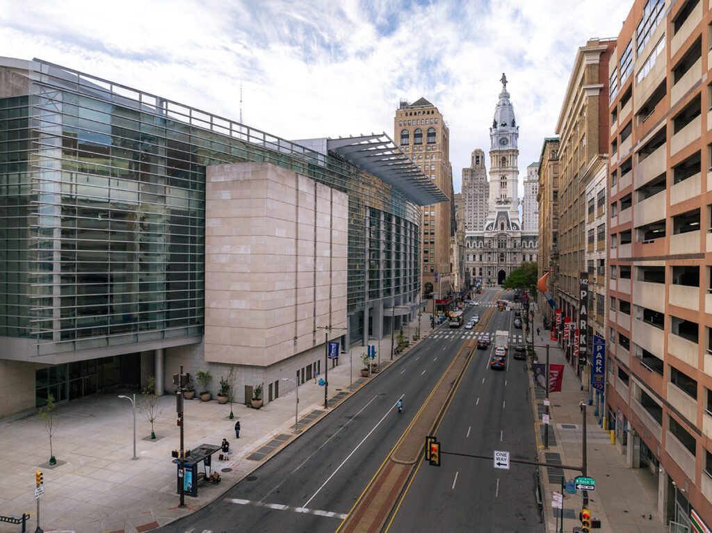 Exterior of the Pennsylvania Convention Center with Philadelphia's City Hall in the background.