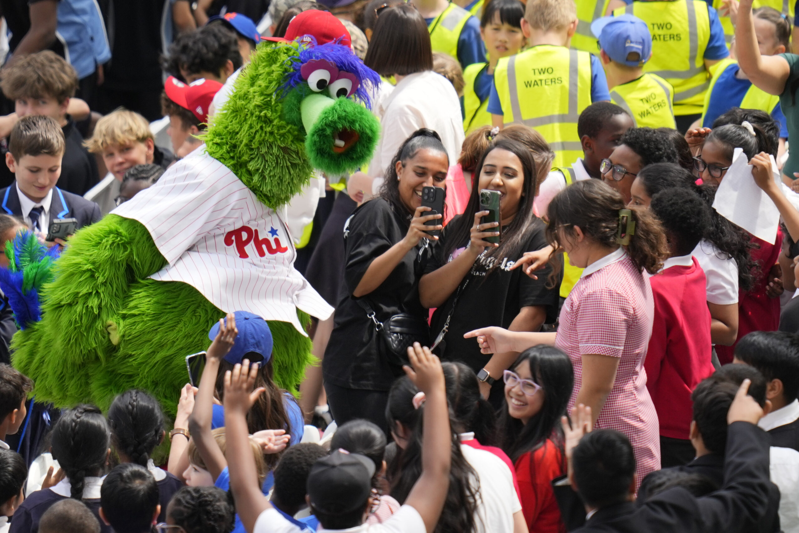 The Phillie Phanatic in the stands at a stadium with fans.