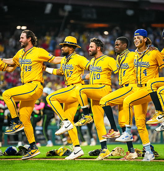 A line of baseball players, dressed in yellow, doing the cancan dance.