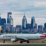 An American Airlines airplane in front of the Philadelphia skyline.