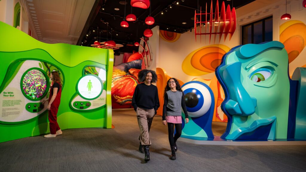 Two people walk through the reimagined Body Odyssey exhibition at The Franklin Institute. 