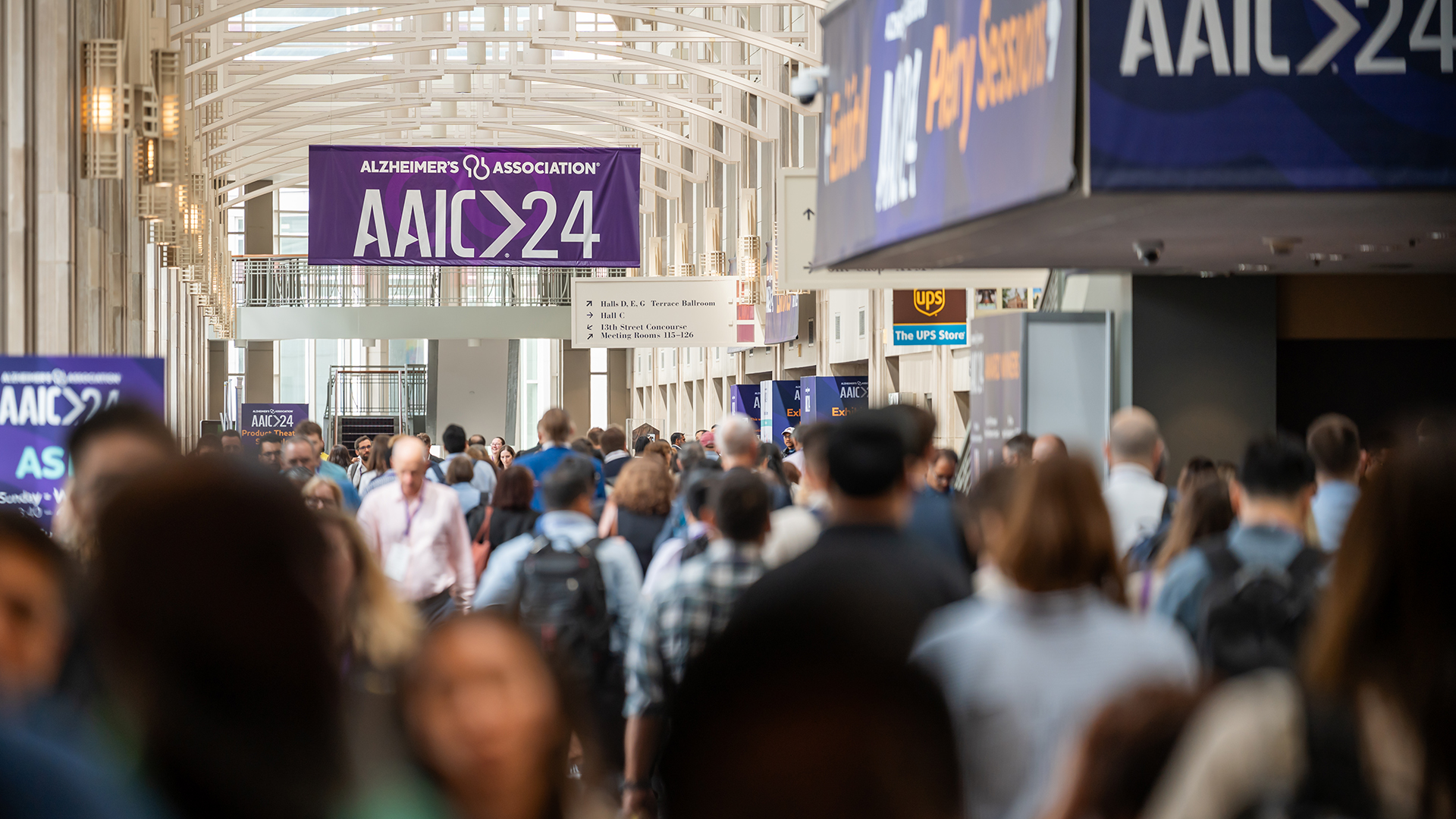 Crowded hallway under signs that say AAIC