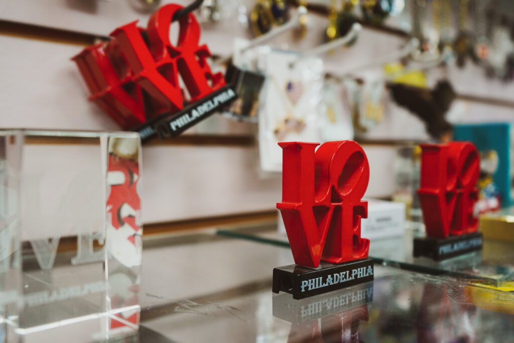 Mini LOVE statues hanging on racks at Xenos Gifts