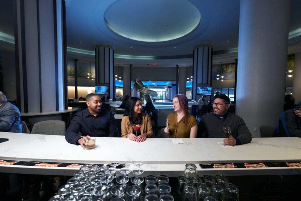 Four patrons are having drinks at the Marriott Bar.